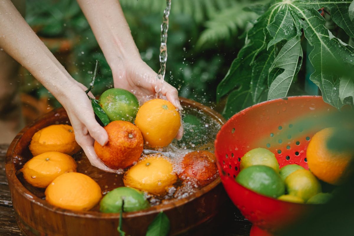 woman washing fresh fruits in tropical orchard