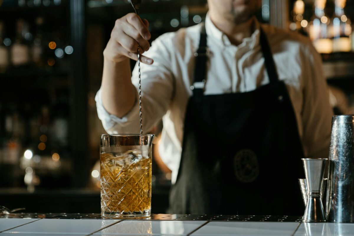 man in white shirt holding clear drinking glass